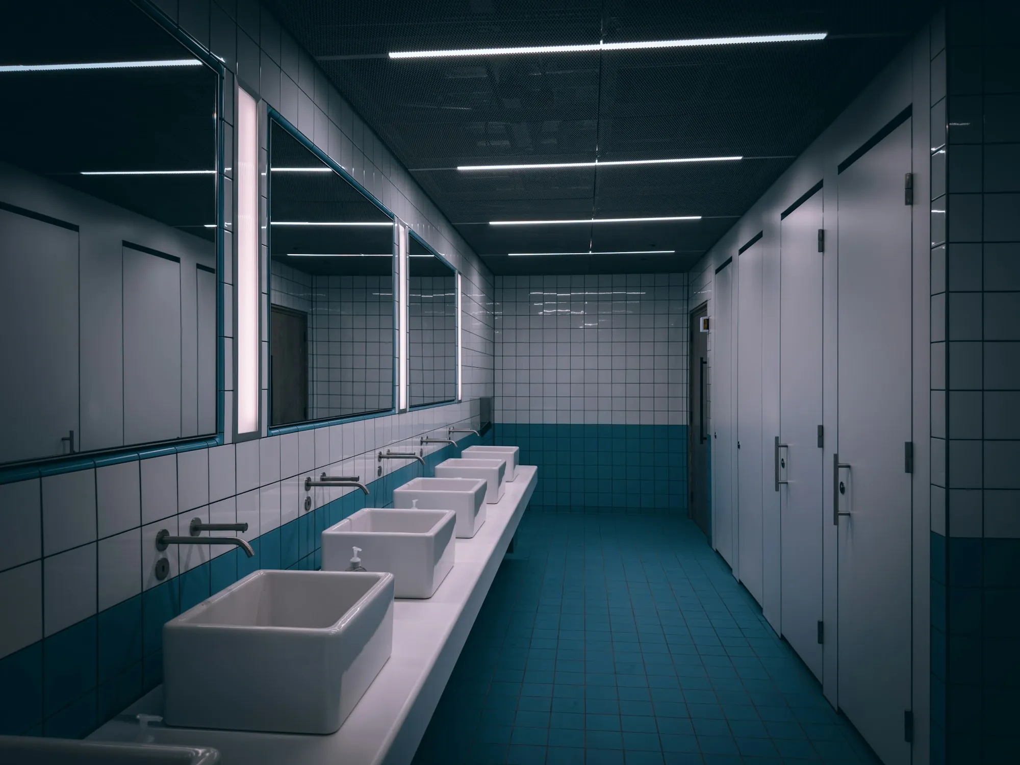 Commercial restroom with a row of sinks and stalls